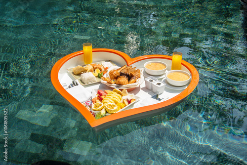 Obraz na płótnie Floating heart-shaped plate with a breakfast of fruits, rice, fish, buns, juice in the swimming pool in the Maldives w salonie