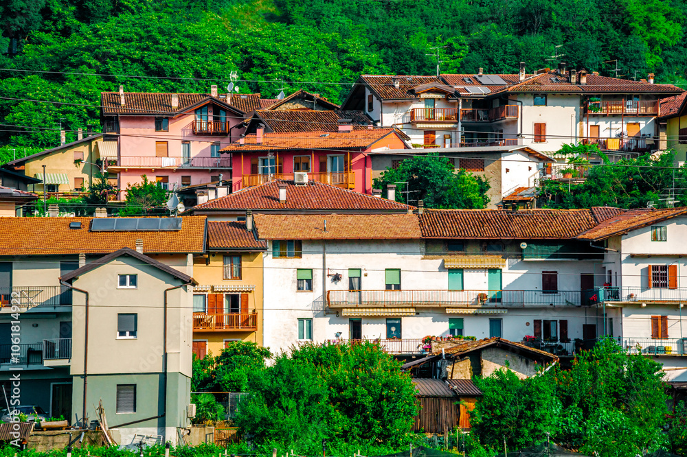 Fototapeta premium Discover the charm of a quaint Italian village with vibrant houses amidst natures beauty