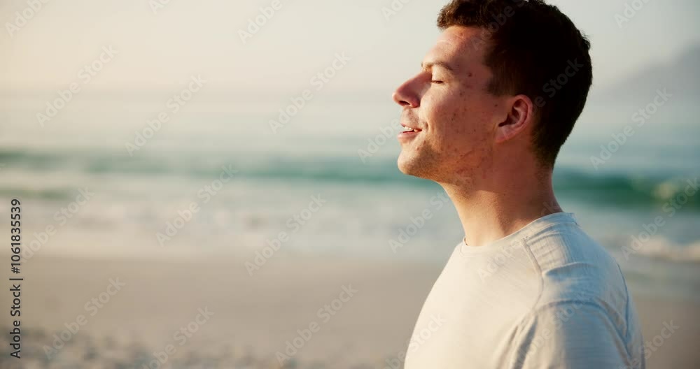 Happy man, relax and breathing with fitness on beach for peace, health and wellness by sea in nature. Young, male person or athlete with smile for fresh air, breeze or calm environment on ocean coast