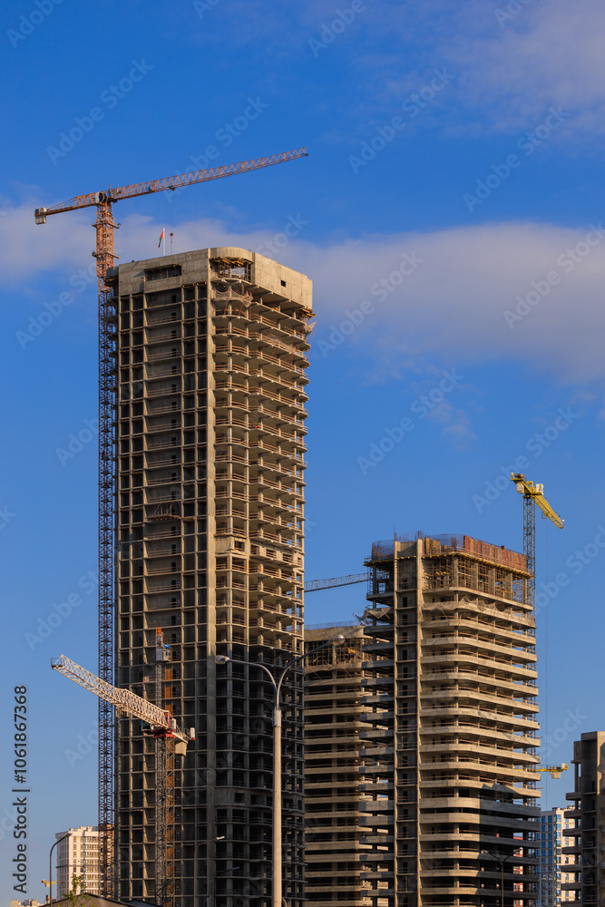 Construction cranes and new buildings, construction work of modern skyscrapers on a sunny day. Construction cranes and new buildings, construction work of modern skyscrapers on a sunny day.