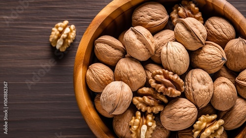 A rustic wooden bowl filled to the brim with walnuts resting on a wooden table