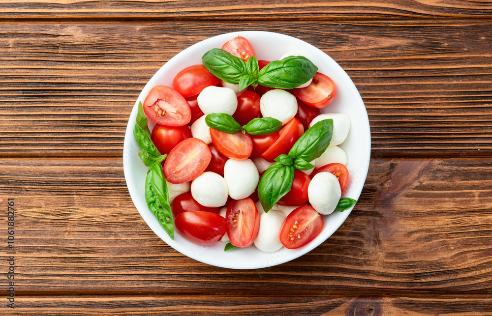 Basil leaves , cherry tomatoes and mozzarella cheese . In bowl food photography Basil leaves , cherry tomatoes and mozzarella cheese . In bowl food photography
