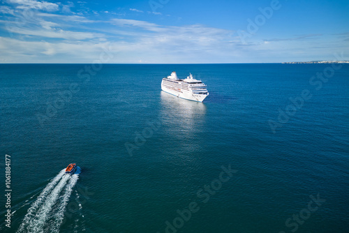An excursion boat heads towards big cruise ship. Vacationing on a cruise