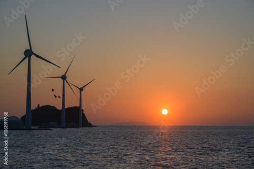 on the beach with a wind turbine and an island in the background taken at the tando island port of Korea.