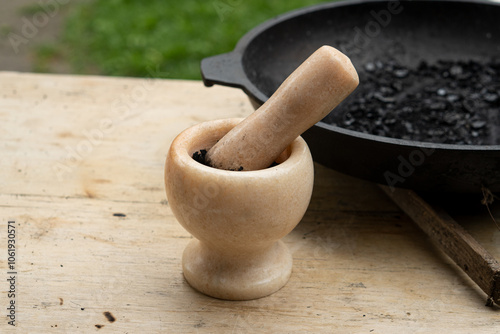 Black powder in a marble mortar close-up photo