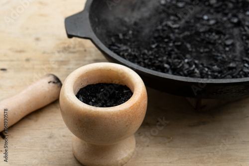 Black powder in a marble mortar close-up photo