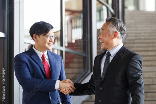 Two Asian businesspeople having a business discussion in the office building.