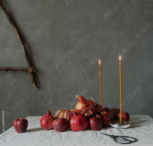 Autumn still life harvest Thanksgiving table serving with pumpkins pommegranates and grapes on linen cloth with candles modern minimalist scandinavian sustainable eco styling