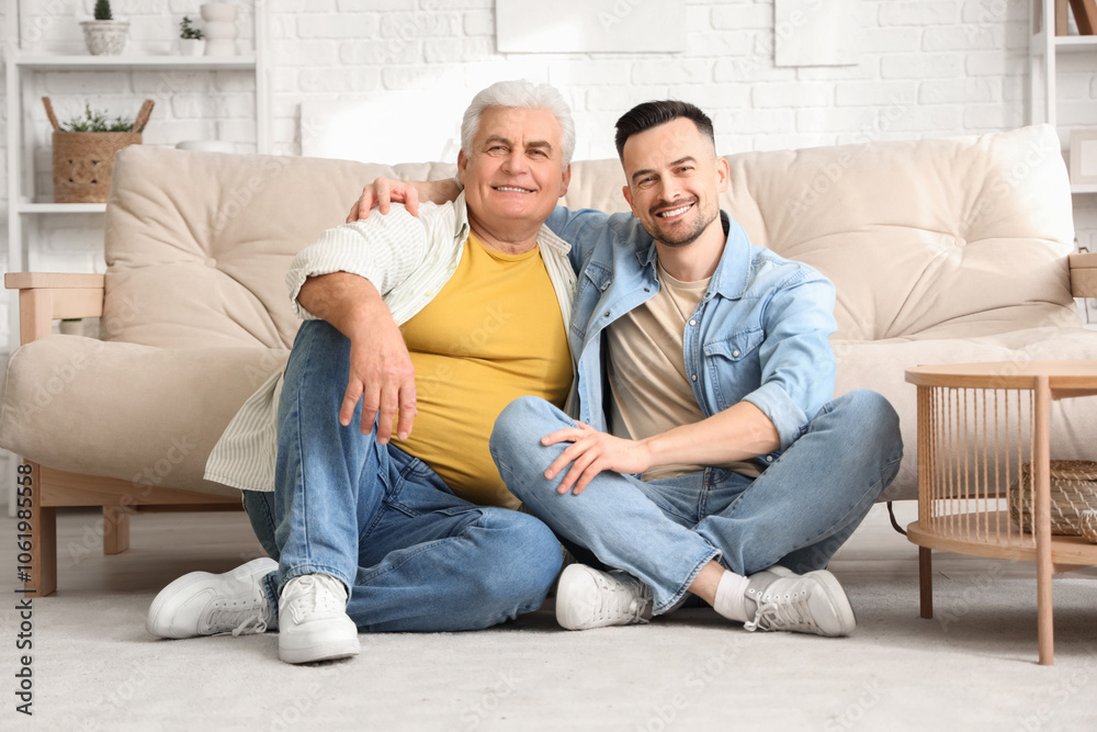 Mature man with his son hugging at home Mature man with his son hugging at home