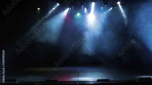 An empty stage of the theater, lit by spotlights and smoke before the performance