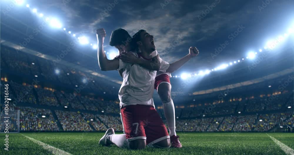 Two football players selebrating a goal. Professional stadium with animated crowd at night.