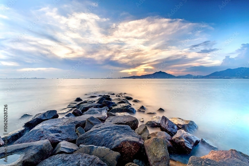 Obraz premium Serene Sunrise Over Rocky Seashore Landscape