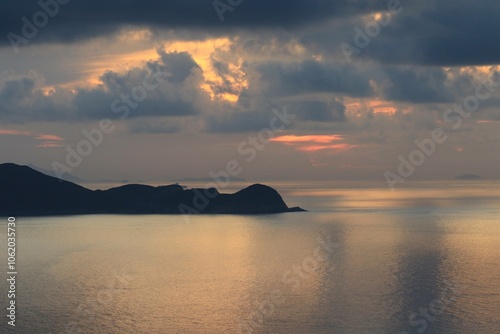 Serene Sunset Over Calm Ocean with Cloudy Sky