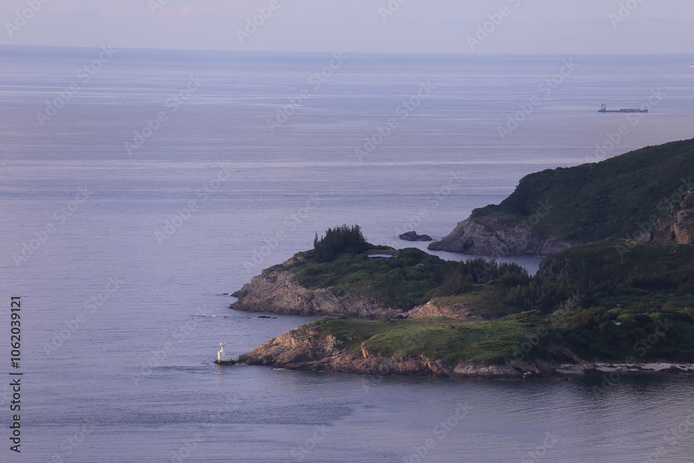 Scenic Coastal View with Lighthouse and Distant Ship at Dusk Scenic Coastal View with Lighthouse and Distant Ship at Dusk