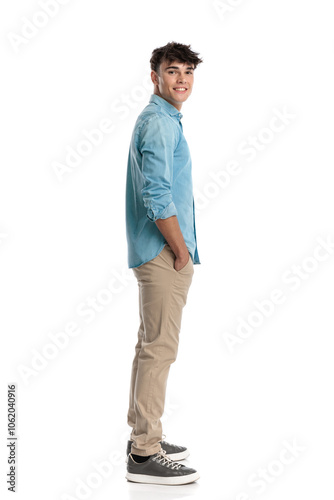 casual young man standing in line with hands in pockets