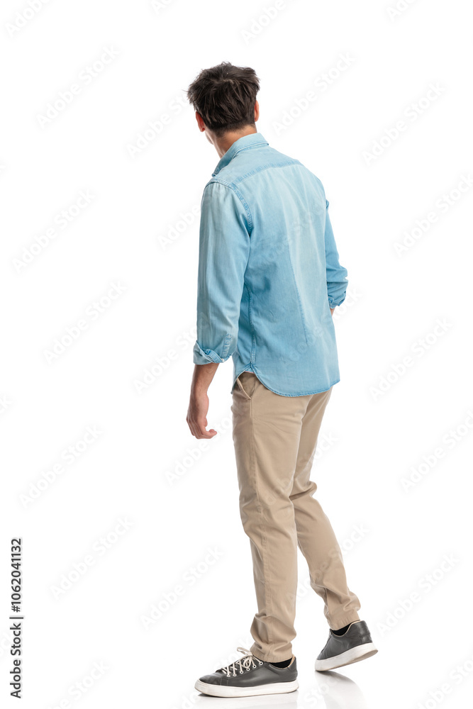 side view of casual young student walking and looking away side view of casual young student walking and looking away
