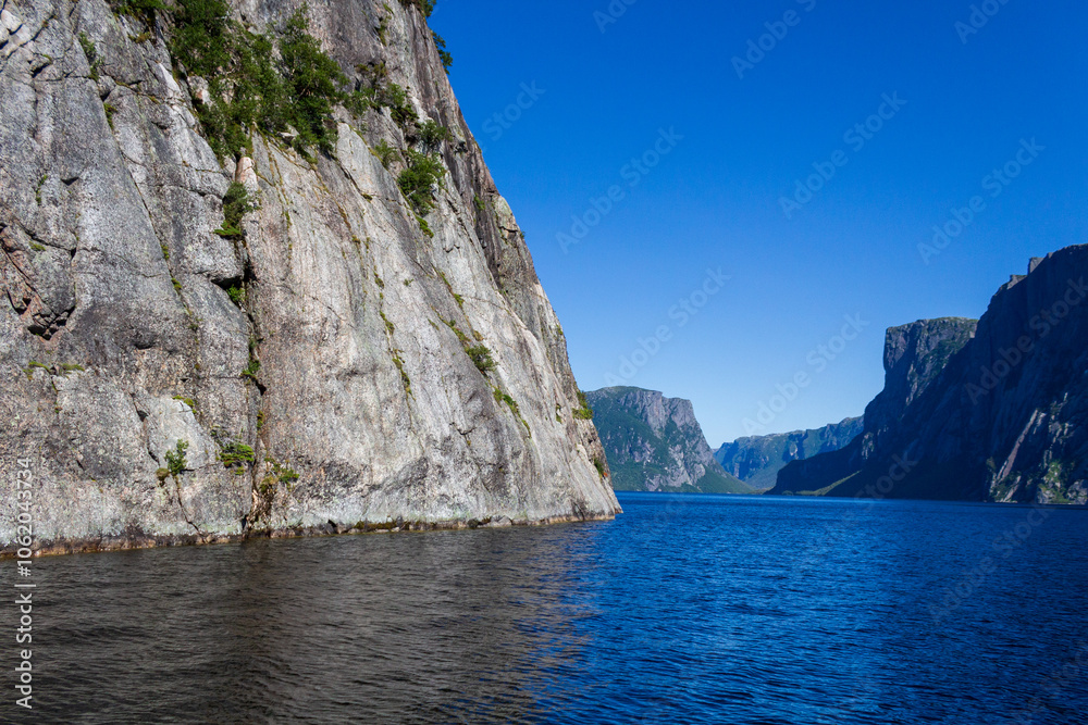 Fototapeta premium Stunning Rocky Cliffs Overlooking a Serene Blue Fjord