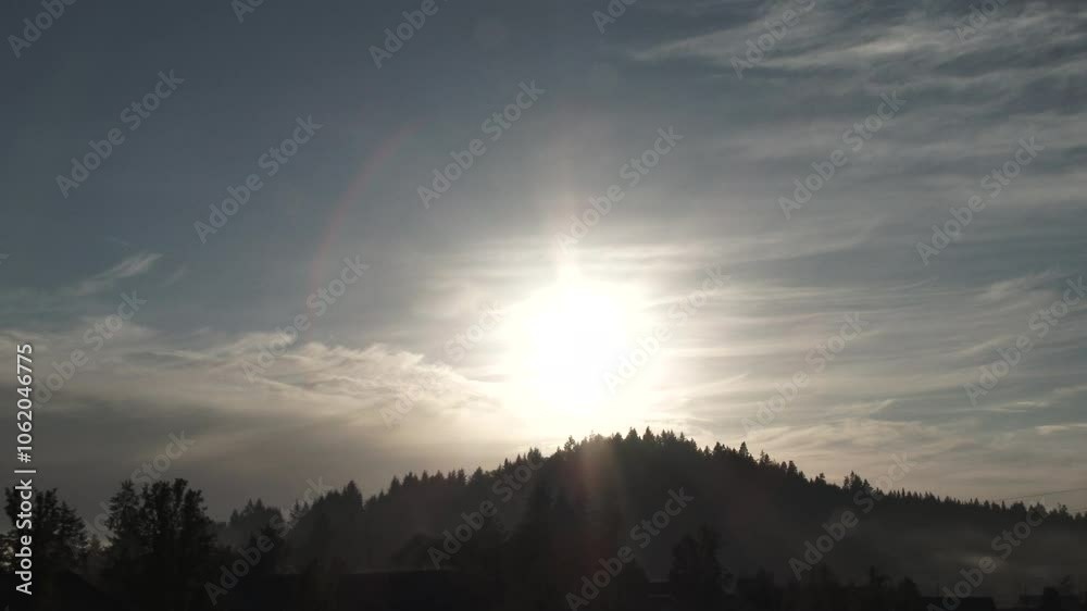 Sunset time lapse over forest hillside with sun setting behind trees with clouds passing and beautiful fog rolling through. Sunset time lapse over forest hillside with sun setting behind trees with clouds passing and beautiful fog rolling through.