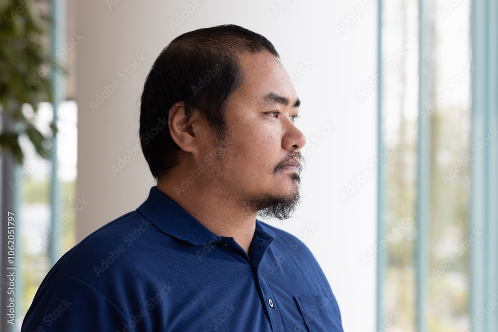 Portrait of pensive, thoughtful middel aged Asian man thinking, planning, finding a good idea Portrait of pensive, thoughtful middel aged Asian man thinking, planning, finding a good idea