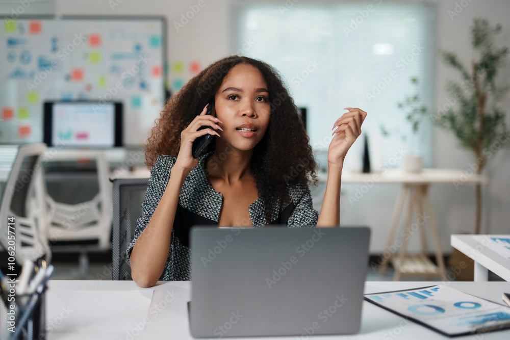 Young manager using smartphone and laptop, managing business projects and tasks, multitasking in workplace Young manager using smartphone and laptop, managing business projects and tasks, multitasking in workplace