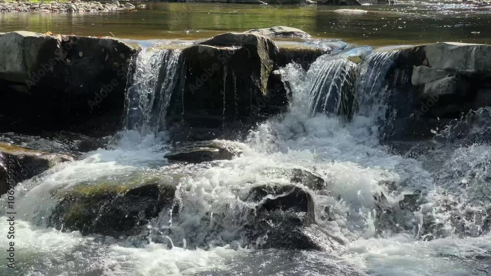 Small cascade waterfall on a mountain river in sunny day Small cascade waterfall on a mountain river in sunny day