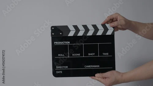 Movie slate or clapperboard hitting with recording frame. Close up hand holding empty film slate and clapping in front of camera clear background. Open and close film slate filming a video production