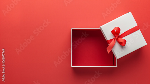 A white box with a red ribbon is open on a red background. The box is empty, but the red ribbon gives the impression of a gift. The red background adds a sense of warmth and excitement to the scene
