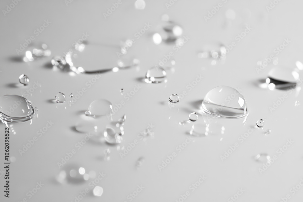 Water droplets scattered on a smooth surface reflecting soft light Water droplets scattered on a smooth surface reflecting soft light