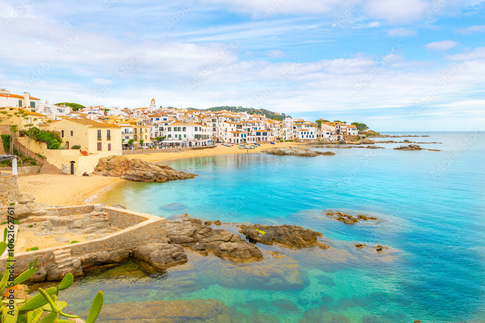 Fototapeta premium The rocky coast, sandy beach and whitewashed village at the fishing town of Calella de Palafrugell, Spain, on the Costa Brava Mediterranean coast. 