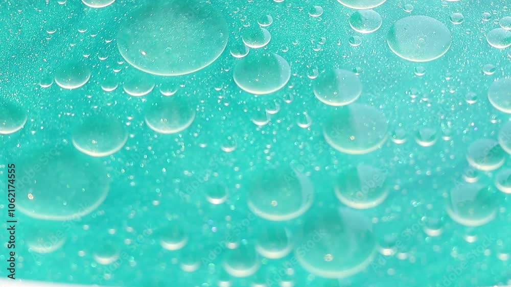 Una toma de cerca de varias burbujas de agua y aceite en movimiento en un fondo de color azul claro