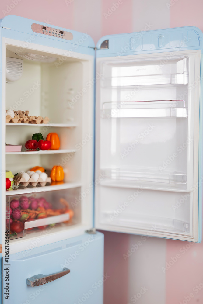 The open door of the refrigerator with food in it. Storage, cooling and freezing of food products. The open door of the refrigerator with food in it. Storage, cooling and freezing of food products.