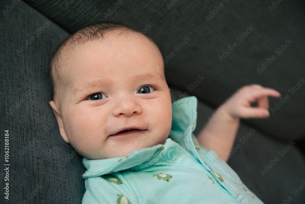 Portrait of a smiling baby boy lying on a sofa Portrait of a smiling baby boy lying on a sofa