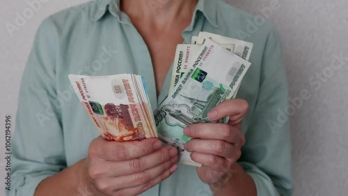 The currency of Russia. Russian rubles in close-up. Financial concept. The background and texture of banknotes. A woman's hands count bells of different denominations. View from above