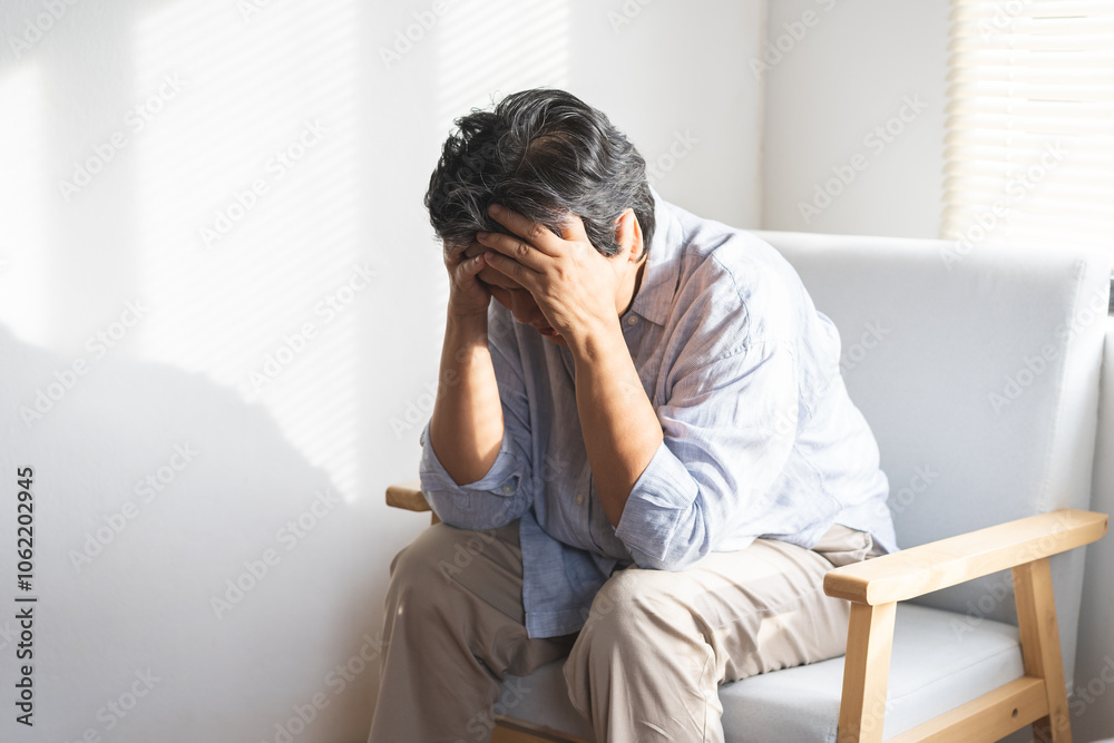 Unhappy asian elderly woman sitting on sofa at home, sick and stress headache feeling depressed suffering trauma from problem trouble tension, old tired difficulty mental health, senior exhausted pain Unhappy asian elderly woman sitting on sofa at home, sick and stress headache feeling depressed suffering trauma from problem trouble tension, old tired difficulty mental health, senior exhausted pain