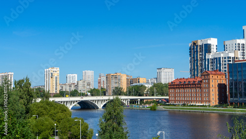 View of Makarovsky bridge and quarter on embankment of city pond, Iset River, Yekaterinburg, Russia. View from Boris Yeltsin Presidential Center photo