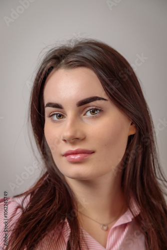 Portrait of young woman showing perfect eyebrows after permanent makeup treatment