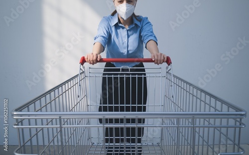 Woman in a face mask pushing a shopping cart.