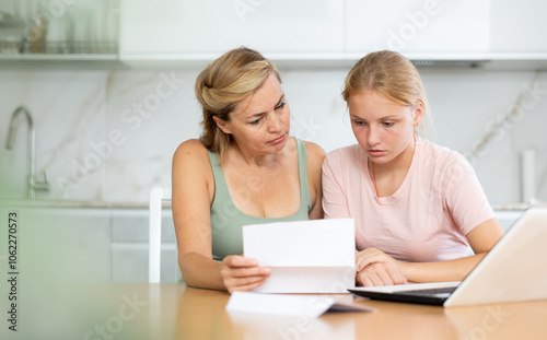 Upset and distressed mother and teenager daughter reads letter and learns unpleasant news about refusal to appoint presidential scholarship