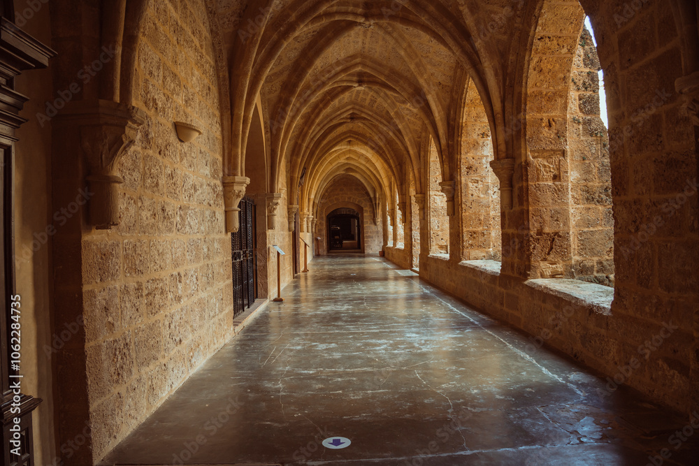 Fototapeta premium Serene Stone Archways of an Ancient Monastery Corridor