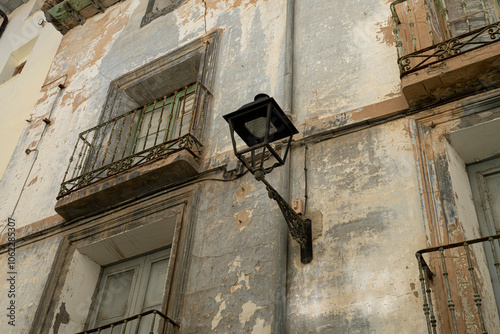 Vintage Street Lamp on Weathered Building Facade