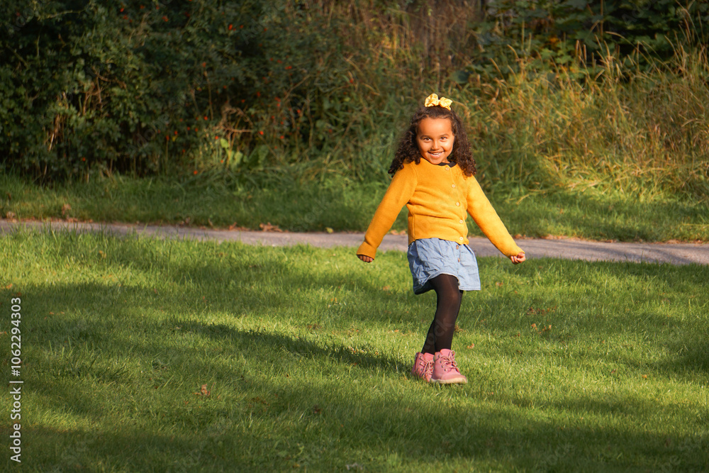A little girl that is standing in the grass