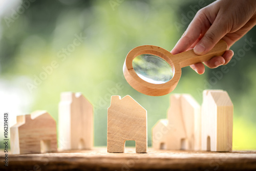 Businessman use the magnifying glass with scan and x-ray with searching the home model in the public park, Loan for real estate or saving money for buy a new house to family in the future concept.