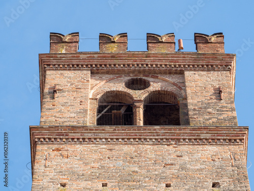 Belfry of an italian medieval church showing brick walls and arches with clear sky in Busseto, Parma, Italy