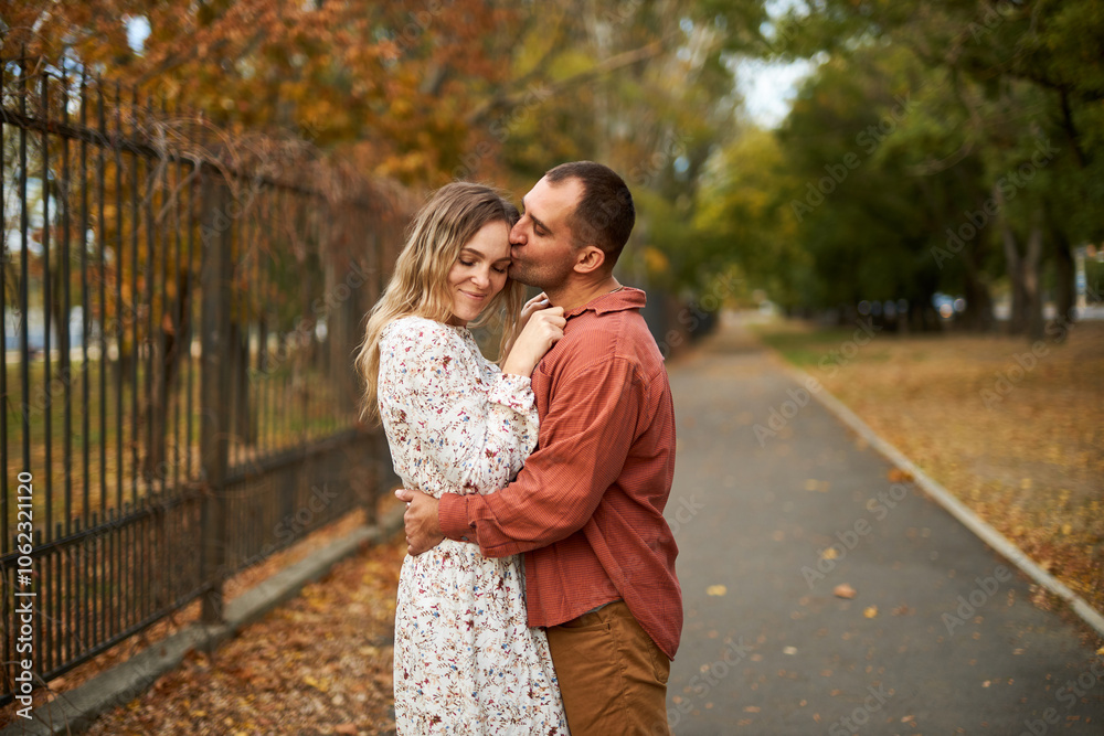 Beautiful and happy couple hugging and smiling while enjoying their time in Autumn Park Beautiful and happy couple hugging and smiling while enjoying their time in Autumn Park