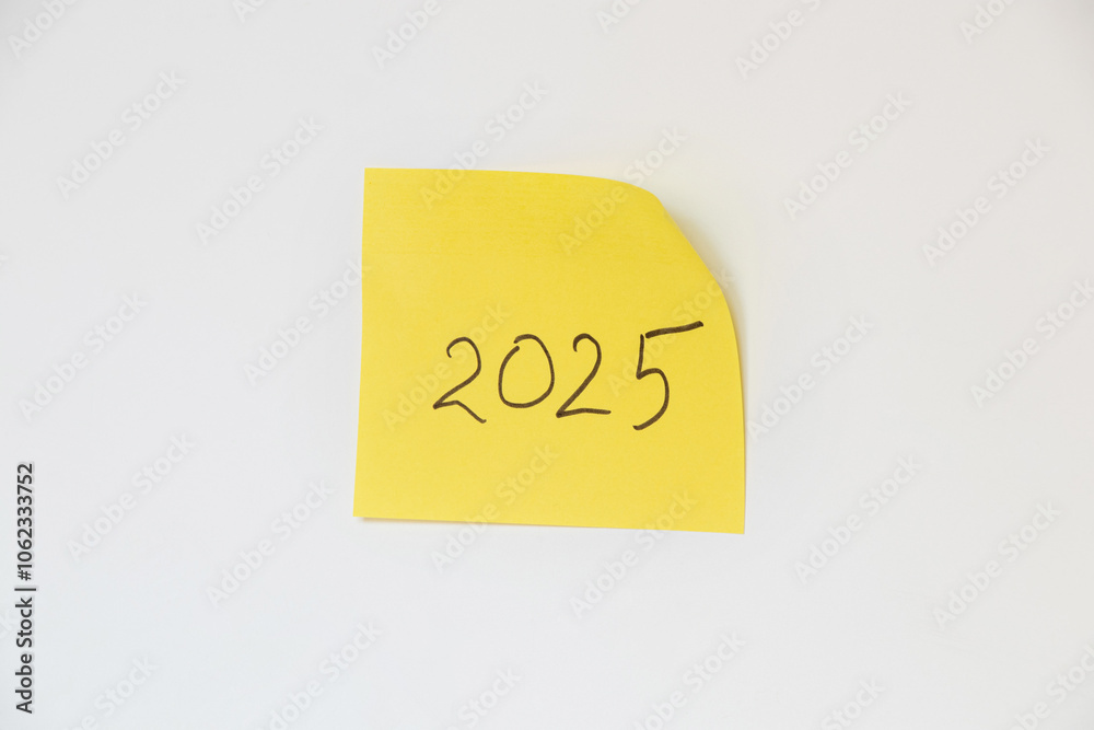 2025 handwritten on a yellow piece of paper on a white background, happy new year 2025 handwritten on a yellow piece of paper on a white background, happy new year