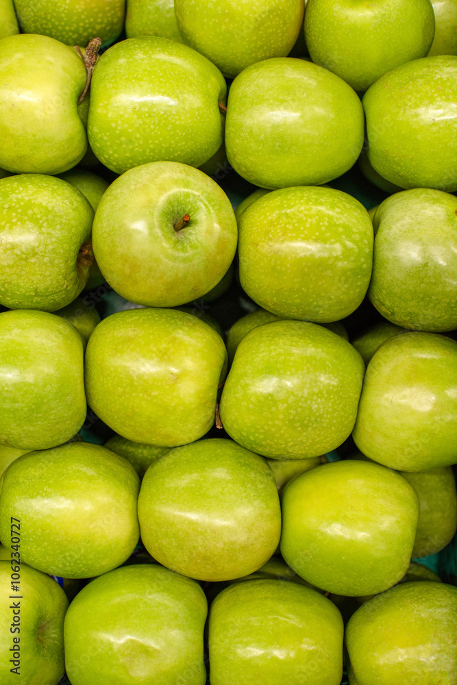 Green apples background. Ripe, juicy green apples on the counter at the grocery market, top view Green apples background. Ripe, juicy green apples on the counter at the grocery market, top view