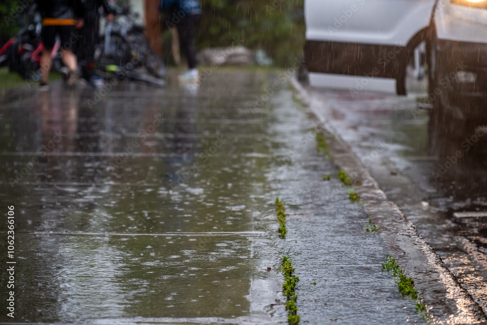 Fototapeta premium Sidewalk during a rain downpour with standing water