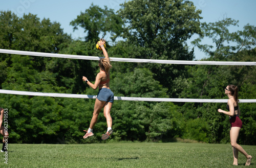 Volleyball player hitting the ball during a summer grass doubles game photo