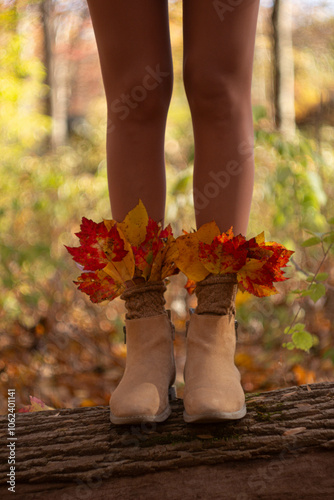 Autumn, fall, leaves, legs and shoes. Conceptual image of legs in boots on autumn leaves. Slender legs of a girl in beige boots in the forest