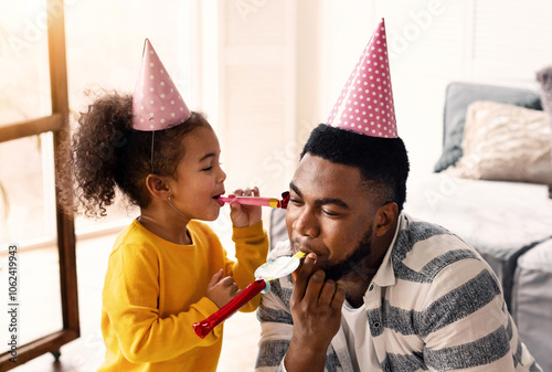 African american dad and daughter blowing in fifes photo